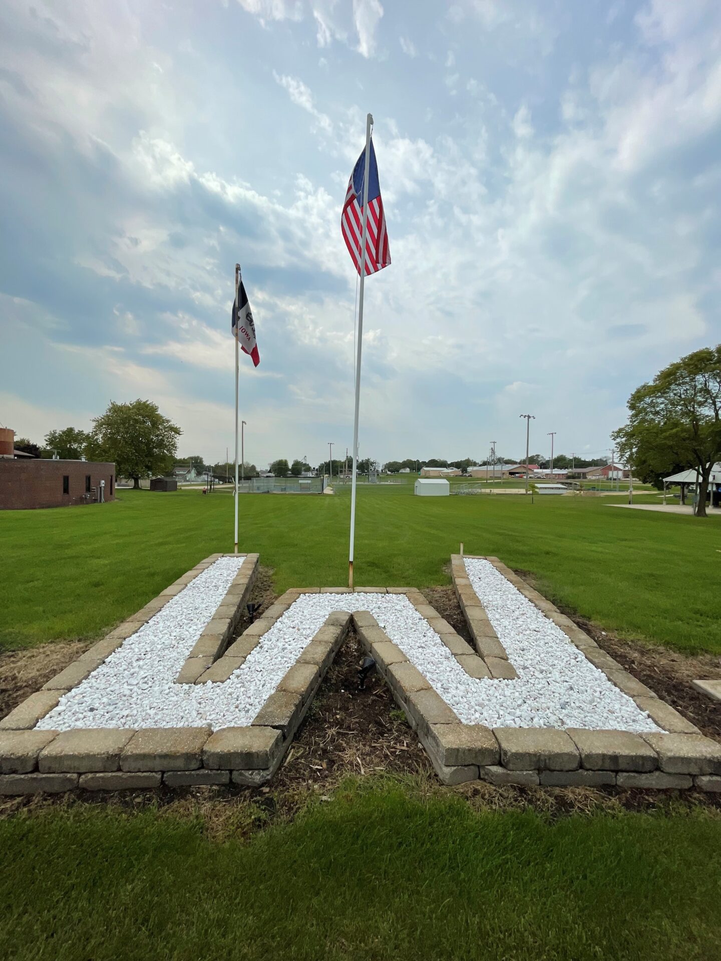 landscaped "W" with iowa flag and US flag flying
